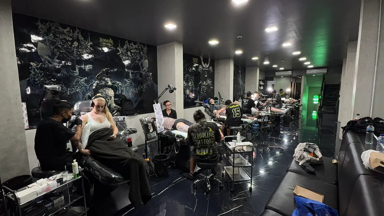 Bloodline Tattoo Bali studio floor with artists at work and Bloodline Bali branding