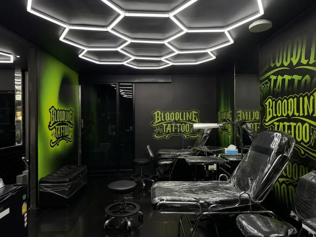 Bloodline Tattoo Phuket studio floor with neon branding and hexagonal ceiling lights