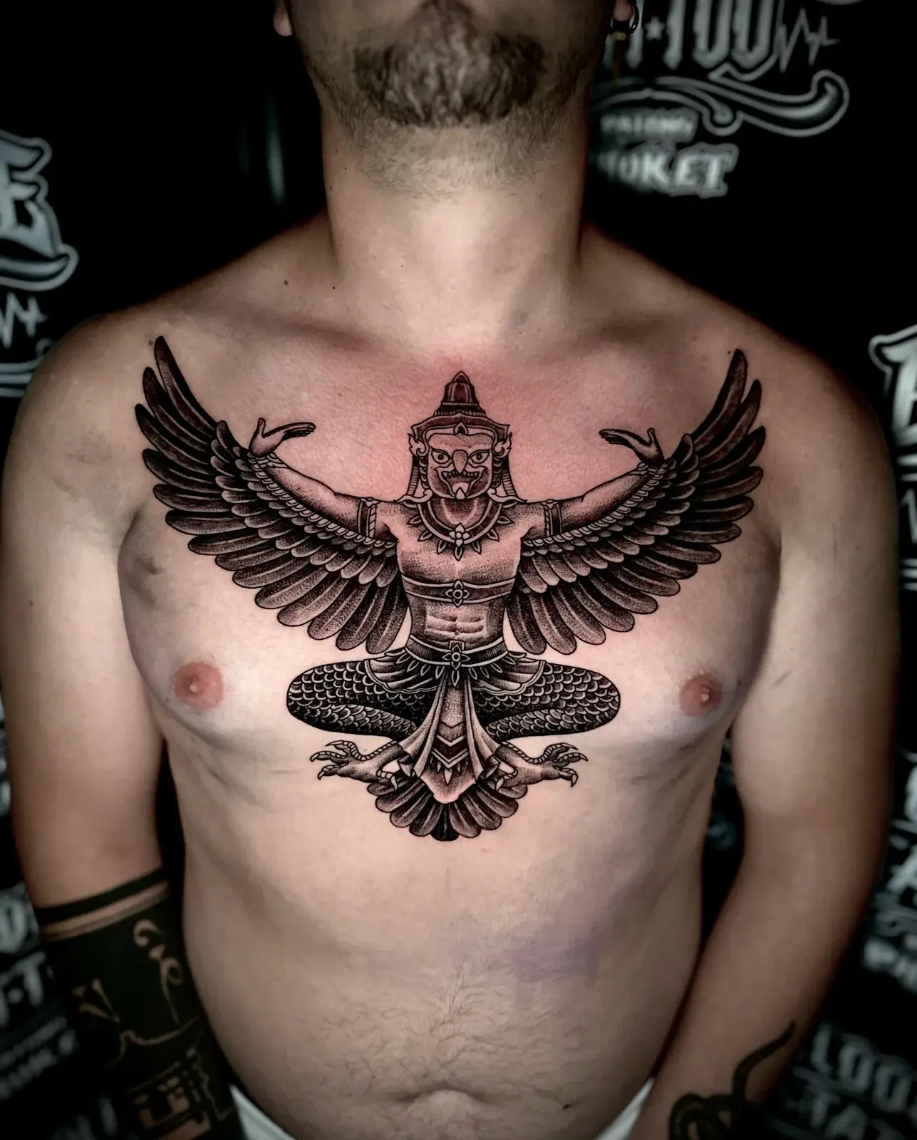 Garuda Sak Yant with outstretched wings, ornate headdress, and detailed feather shading centered on the chest at Bloodline Tattoo Phuket.