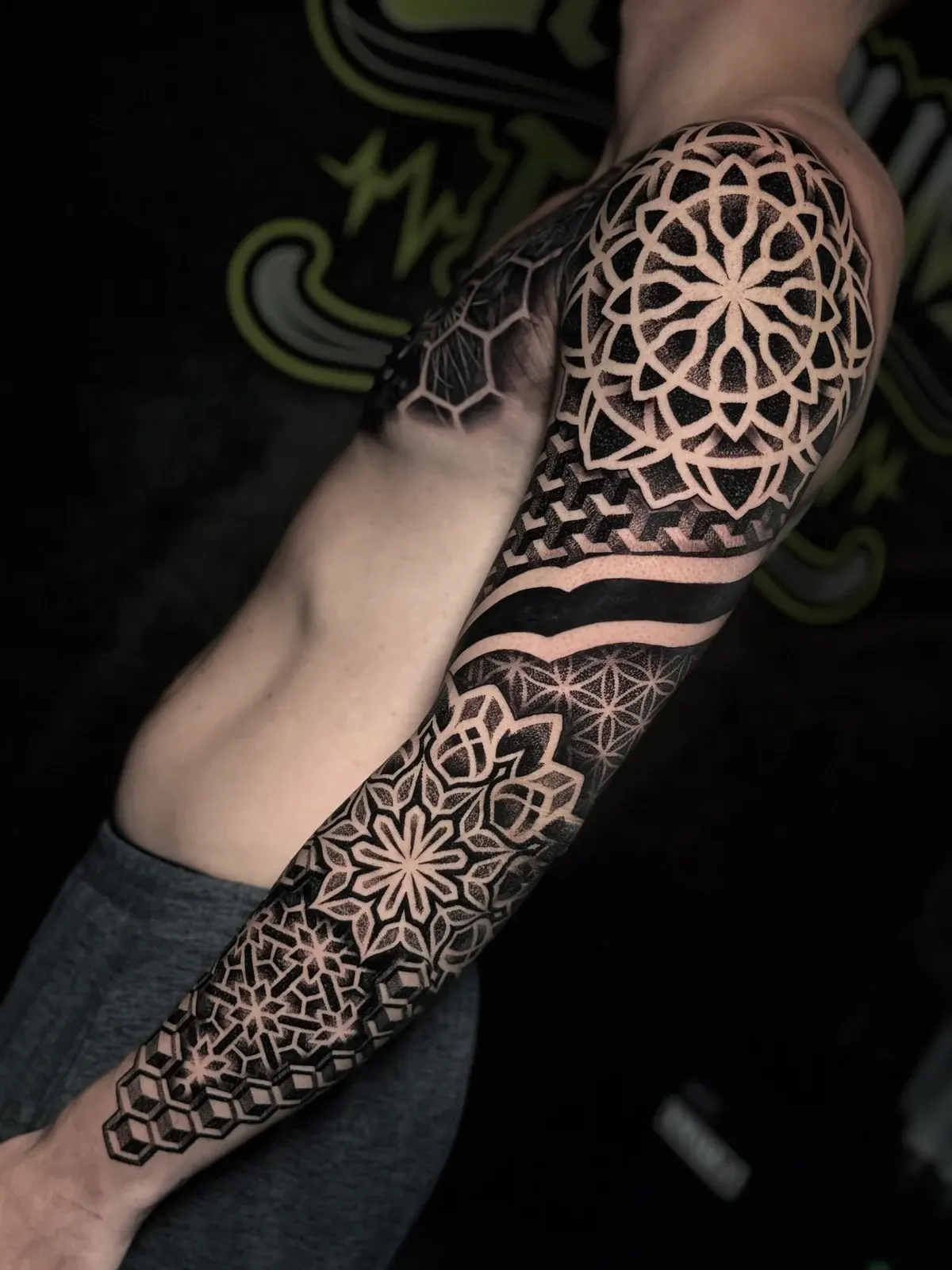 Full mandala sleeve with shoulder and forearm lotus mandalas, Flower of Life bands, and 3D cube dotwork near the wrist at Bloodline Tattoo Phuket.
